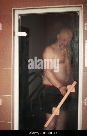 Contenu homme se relaxant dans un sauna Banque D'Images