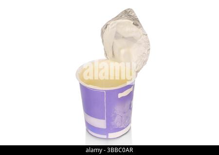 Délicieuse crème sure dans une tasse en plastique isolée sur un fond blanc, gros plan. Banque D'Images