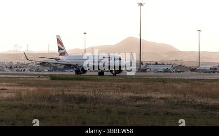 Larnaca, Chypre - 24 mai 2024 : avion British Airways au coucher du soleil avec des éoliennes en arrière-plan Banque D'Images