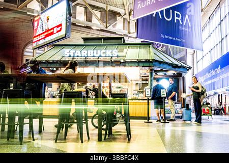 Intérieur de South Station Boston - temporisation des passagers à l'intérieur du centre de transport attendant Starbucks Banque D'Images