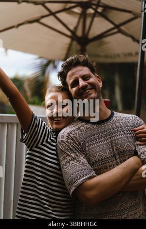 Portrait d'heureux amis masculins et féminins posant dans la cour arrière à la fête Banque D'Images