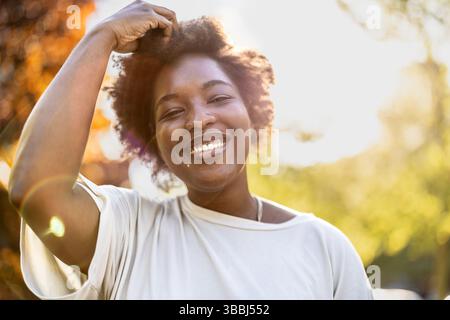Jeune femme souriante dans le parc par une journée ensoleillée Banque D'Images