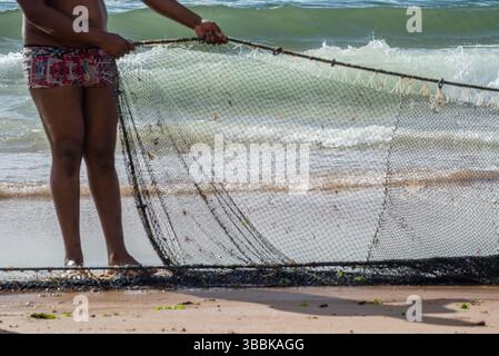 Demi-corps d'un pêcheur non identifié tirant un filet de pêche. fruits de mer, passe-temps. Brésil Banque D'Images