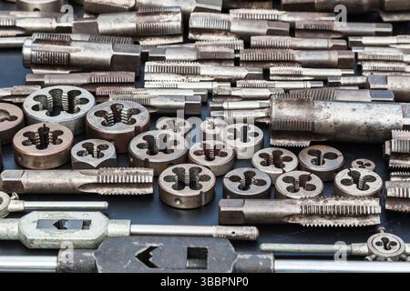 Tarauds, matrices et clés pour tarauds et matrices sur fond noir. Outil manuel pour filetage. Banque D'Images