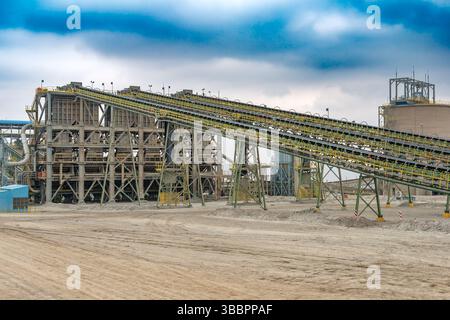 De vastes bandes transporteuses transportent régulièrement le minerai de cuivre vers l'installation de concassage dans une usine de traitement située dans une mine située au Chili. Banque D'Images