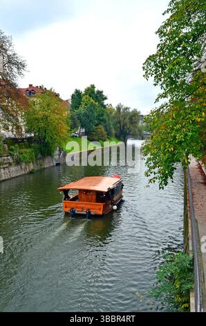 Ljubljana Slovénie. Juillet 26 2012. Croisière traditionnelle en bois sur la paisible rivière Ljubljanica entourée d'arbres et d'un paysage urbain Banque D'Images