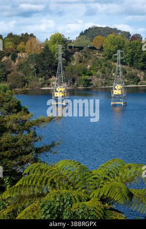 Pylônes électriques dans le lac Karapoti, Cambridge, Waikato, Île du Nord, Nouvelle-Zélande Banque D'Images