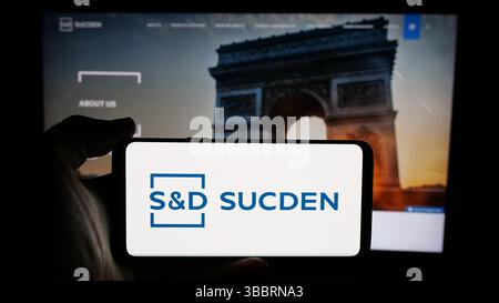 Dans cette illustration photo, une personne tient un téléphone portable avec le logo de la société française sucres et Denrees (Sucden) sur l'écran devant la page web. Banque D'Images