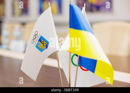 Le drapeau ukrainien et le drapeau du Comité olympique se tiennent sur une table lors d'une conférence Banque D'Images