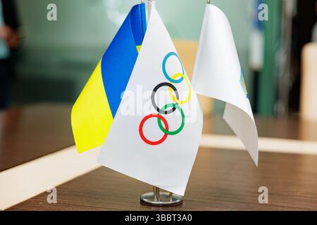 Le drapeau ukrainien et le drapeau du Comité olympique se tiennent sur une table lors d'une conférence Banque D'Images