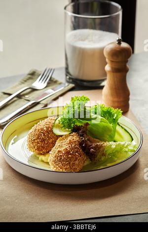 Escalopes de poulet panées kiev servies sur assiette avec purée de pommes de terre, concombre frais et laitue Banque D'Images