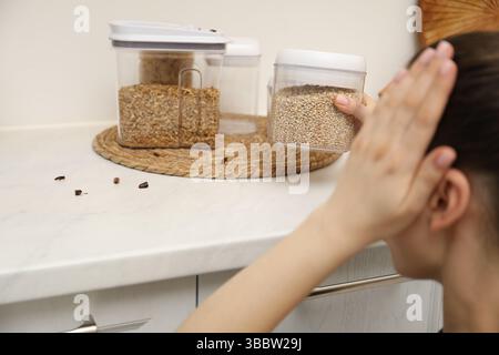 Femme regardant des cafards sur le comptoir dans la cuisine, gros plan Banque D'Images