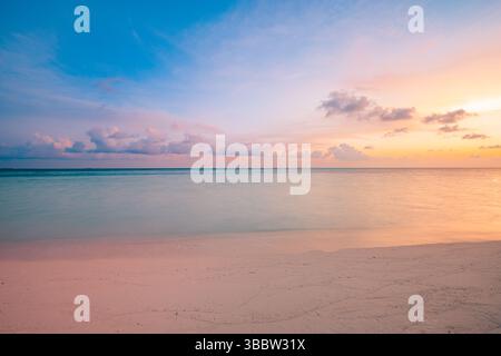 Coucher de soleil de rêve sur la mer tranquille avec ciel doré et plage de sable, vue inspirante méditation et détente, horizon océan paisible dans la soirée d'été Banque D'Images