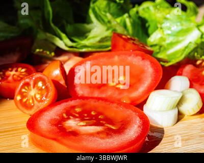 Une salade d'été fraîche avec des tomates, des cœurs de laitue et des oignons de printemps, tous cultivés sur place dans le jardin, servi coloré et croustillant - parfait pour un léger, hea Banque D'Images