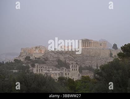 Athènes, Grèce, 16 mai 2025. L'ancienne Acropole est entourée de brume tandis qu'Athènes est couverte de nuages de poussière. Une épaisse couverture de poussière saharienne a balayé la capitale grecque vendredi, jetant de la brume sur la ville et suscitant des avertissements sanitaires de la part des autorités. Crédit : Dimitris Aspiotis/Alamy Banque D'Images