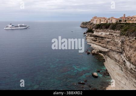 20 avril 2025, France, Bonifacio : vue de la ville de Bonifacio sur l'île de Corse (France) le 20.04.2025. La vieille ville médiévale (ville haute) peut être vue sur un promontoire de calcaire et de grès, dont une grande partie descend verticalement vers la mer. Le navire de croisière Seabourn Ovation est amarré dans la baie. Bonifacio (Corse Bunifaziu ; Ligurian Bunifazziu ou Bonifacio) est une ville portuaire située dans le sud de l'île méditerranéenne française de Corse (Corse, Corse) dans le département de Corse-du-Sud. Située sur un plateau rocheux semblable à une péninsule, la vieille ville est l'un des m de l'île Banque D'Images