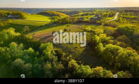Vue aérienne depuis Apple Blossom Overlook Park montrant des collines verdoyantes et des terres agricoles au coucher du soleil avec une lumière dorée sur le paysage rural du Wisconsin. Banque D'Images