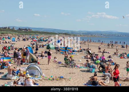 Troon, Royaume-Uni. 17 mai 2025. Le temps chaud et ensoleillé avec des températures allant jusqu'à 28C, a attiré des milliers de personnes à South Beach, Troon sur le Firth of Clyde, côte Ayrshire, sud-ouest de l'Écosse, Royaume-Uni . Crédit : Findlay/Alamy Live News Banque D'Images