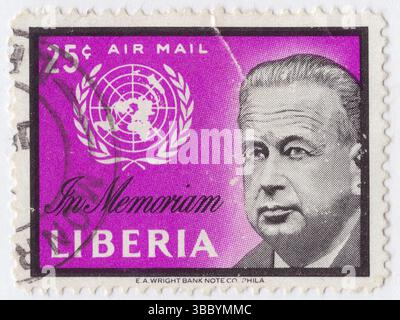 LIBÉRIA - 1962 février : timbre de la poste aérienne de 25 cents en lilas noir et rouge représentant un portrait de Dag Hammarskjold et de l'emblème des Nations Unies, in memoriam Dag Hammarskjold Banque D'Images