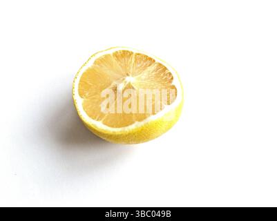 Un citron est coupé en deux et l'intérieur est montré. Le citron est jaune et a un goût aigre Banque D'Images