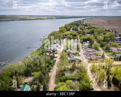 Vue sur une petite ville avec une rivière qui la traverse. Les maisons sont réparties le long de la rive et il y a plusieurs bateaux amarrés dans l'eau. S Banque D'Images