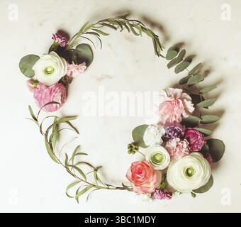 Cadre rond fleuri avec branches et feuilles d'eucalyptus, fleurs plates, vue de dessus avec espace pour les copies Banque D'Images