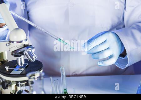Faire de la recherche scientifique est à l'œuvre, l'homme tient la pipette en verre et Banque D'Images