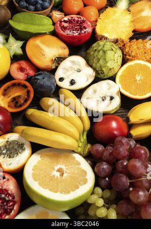 Tableau avec des fruits tropicaux, variété de fruits mélangés sur fond de bois, de la nourriture saine et propre concept de l'alimentation Banque D'Images