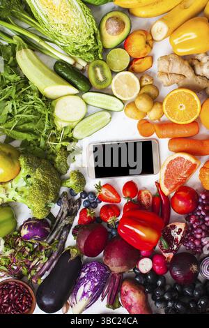 Concept de ferme frais de livraison des légumes biologiques et des fruits. Produits de la ferme, smartphone avec la nourriture vegan, vue du dessus Banque D'Images