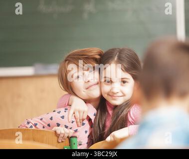 Deux copines happy funny hugging en classe Banque D'Images