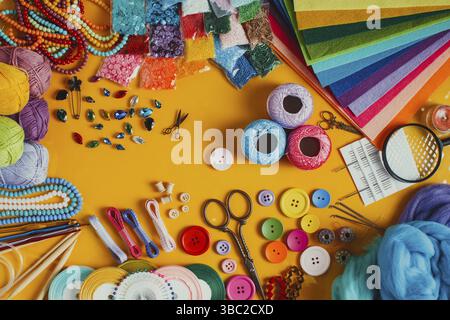 Fournitures artisanales pour tricoter et faire la main créative sur le jaune. Vue de dessus de l'appareil. Organisation des éléments de bricolage, conception de bordures Banque D'Images