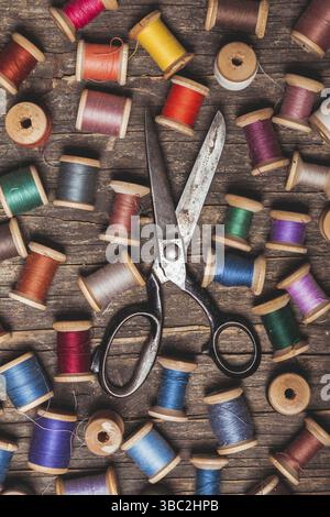 Bobines de couture rétro en bois avec fils colorés et ciseaux vintage Banque D'Images