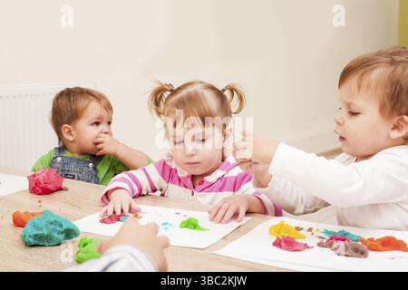 Les enfants font une figure de plasticine sur la table Banque D'Images