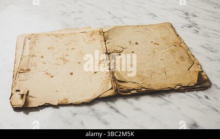 Livre vintage ouvert avec des pages vierges sur une table en marbre. Vieux PC portable, maquette Banque D'Images