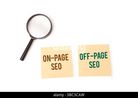 Une loupe se trouve à côté de deux notes adhésives. On lit « SEO ON-PAGE », l'autre « SEO OFF-PAGE ». Banque D'Images