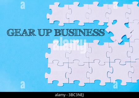 Puzzle avec les mots Gear Up Business écrit dessus. Il manque une pièce au puzzle Banque D'Images