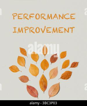 Affiche avec des feuilles et les mots amélioration de la performance écrits dessus. Les feuilles sont disposées en cercle et sont de tailles différentes Banque D'Images