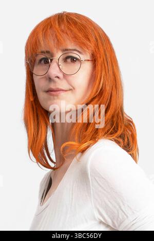 Portrait d'une femme aux cheveux roux devant un paysage d'automne orange Banque D'Images