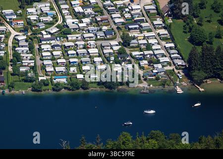 Unterach am Attersee, Autriche. 18 mai 2024. Paysage photographié d'en haut d'un camping directement sur le lac Mondsee près de Unterach am Attersee (Autriche). Le lac Mondsee est une destination touristique importante en haute-Autriche et un lac de baignade populaire. Il existe de nombreux emplacements avec caravanes et remorques, ainsi que des maisons de vacances pavées sur les parcelles des campeurs permanents sur le camping avec accès direct au lac. Crédit : Matthias Balk/dpa/Alamy Live News Banque D'Images