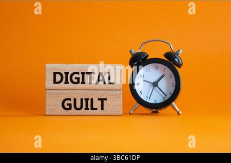 Symbole de culpabilité numérique. Mots conceptuels culpabilité numérique sur blocs de bois. Beau fond orange avec réveil. Business et concept de culpabilité numérique. Banque D'Images