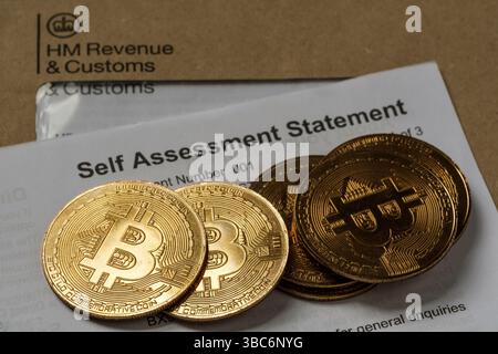 Pièces de crypto-monnaie Bitcoin en plus de la déclaration fiscale d'auto-évaluation de HM Revenue & Customs, concept d'actifs numériques et déclaration fiscale britannique, Stafford, U. Banque D'Images