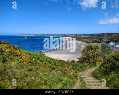 Vue idyllique sur la baie de St Ouen et la plage de sable, mer bllue, collines verdoyantes et marches en bois. Jersey, îles Anglo-Normandes Banque D'Images