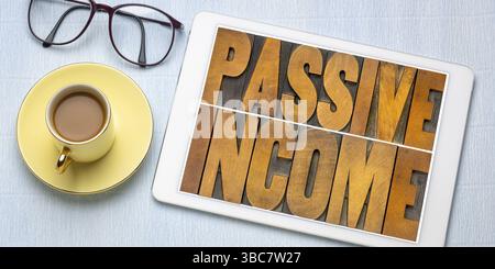 Résumé de mot de revenu passif dans le type de bois de typographie sur une tablette numérique - concept de plat financier d'entreprise Banque D'Images