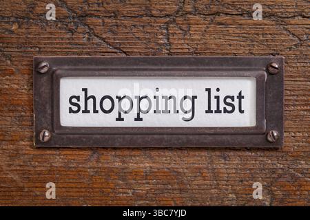 Liste d'achats - - étiquette de classeur, support en bronze contre grunge et bois rayé Banque D'Images