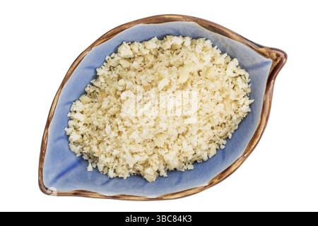 Farine de noix de macadamia dans un bol en céramique isolé en forme de feuille, vue de dessus Banque D'Images