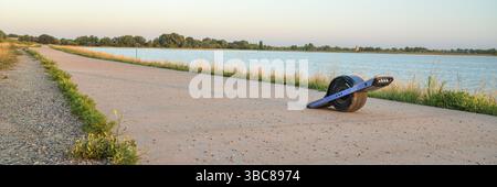 Fort Collins, CO, États-Unis - 11 août 2018 : planche à roulettes électrique Onewheel (transporteur personnel) sur une rive du lac au crépuscule Banque D'Images