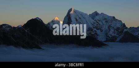 Soleil illuminé montagnes Ama Dablam et Cholatse au coucher du soleil, vue de la vallée de Gokyo, Népal. Banque D'Images