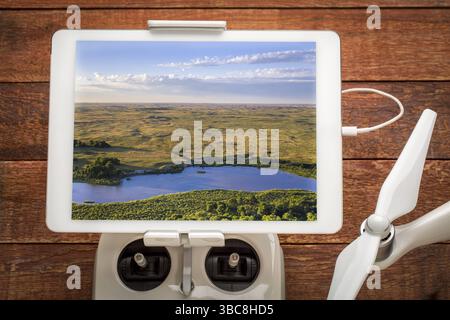 Rivière Dismal peu profonde et large qui traverse les dunes du Nebraska, examinant une image aérienne sur une tablette numérique montée sur un contrôleur radio de drone Banque D'Images