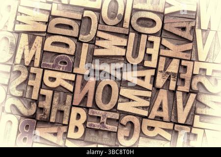 Arrière-plan de blocs d'impression typographique vintage aléatoires teints par des encres de couleur, image teintée sépia Banque D'Images