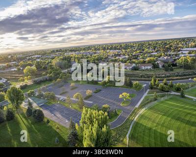 Vue aérienne d'un parc local avec terrains de basket-ball, parking et terrain de baseball à Fort Collins, Colorado, photographiée depuis un drone volant à basse altitude au lever du soleil Banque D'Images